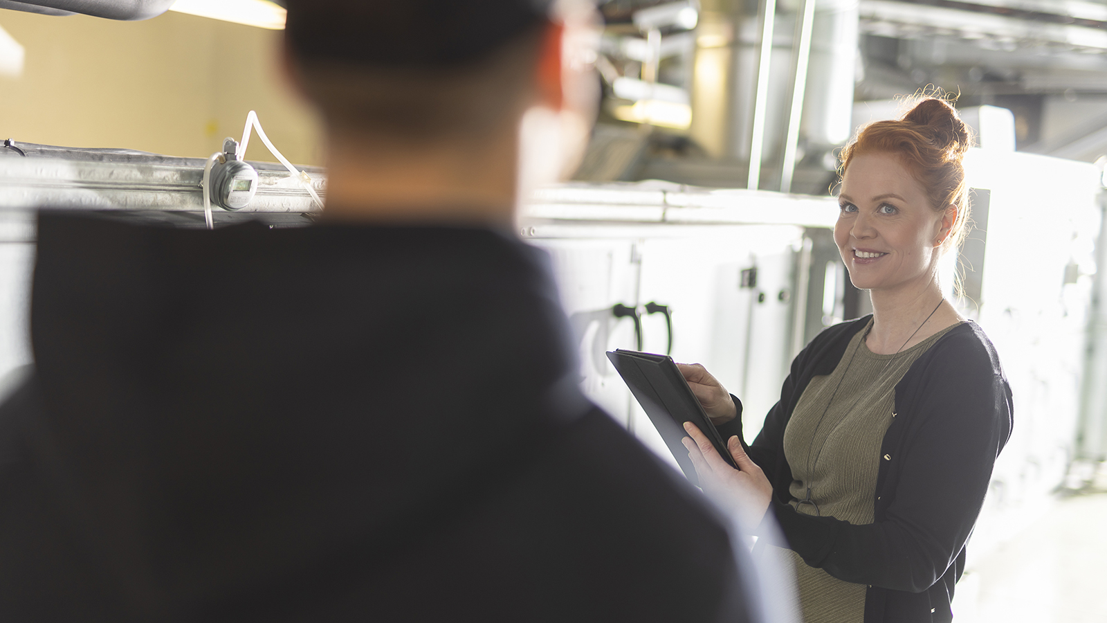 Property manager and maintenance team member discussing real estate management issues in the technical space of an office building.
